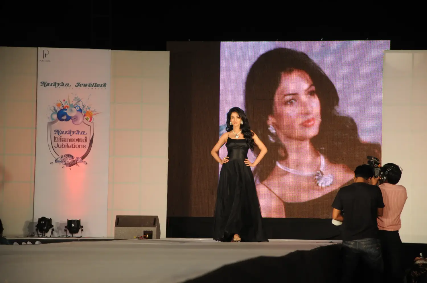 Men lighting ceremonial lamp at event with ITT banner in background